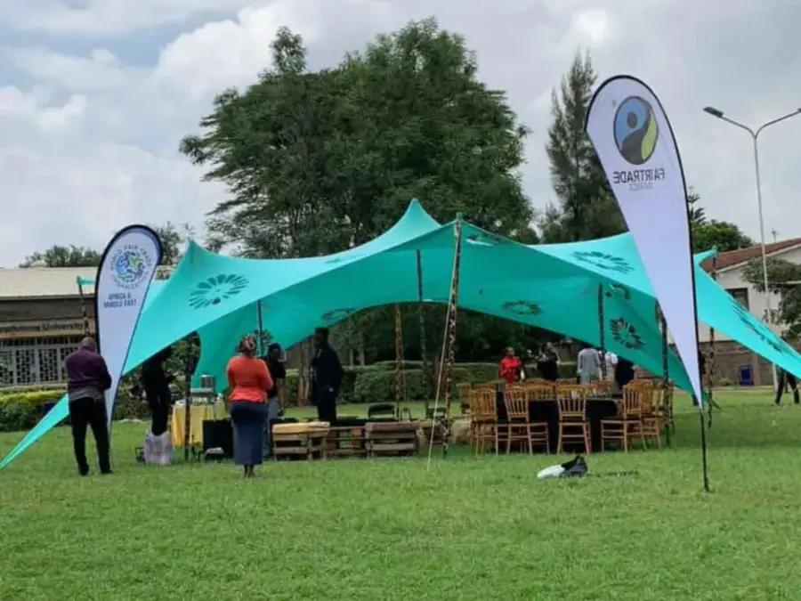 Teal stretch tent set up on a lawn with Britam and Fairtrade Africa banners, hosting an outdoor corporate or community event.